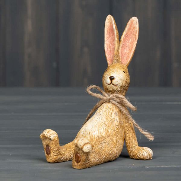 Relaxed sitting rabbit ornament in a brown rustic style with a string bowtie