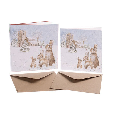 Wrendale Christmas card box set of 8 with three bunnies sat in the snow in front of a country church